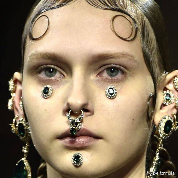 Na passarela da Givenchy as modelos carregaram piercings de pedrarias verdes no nariz, bochechas, queixo e orelhas